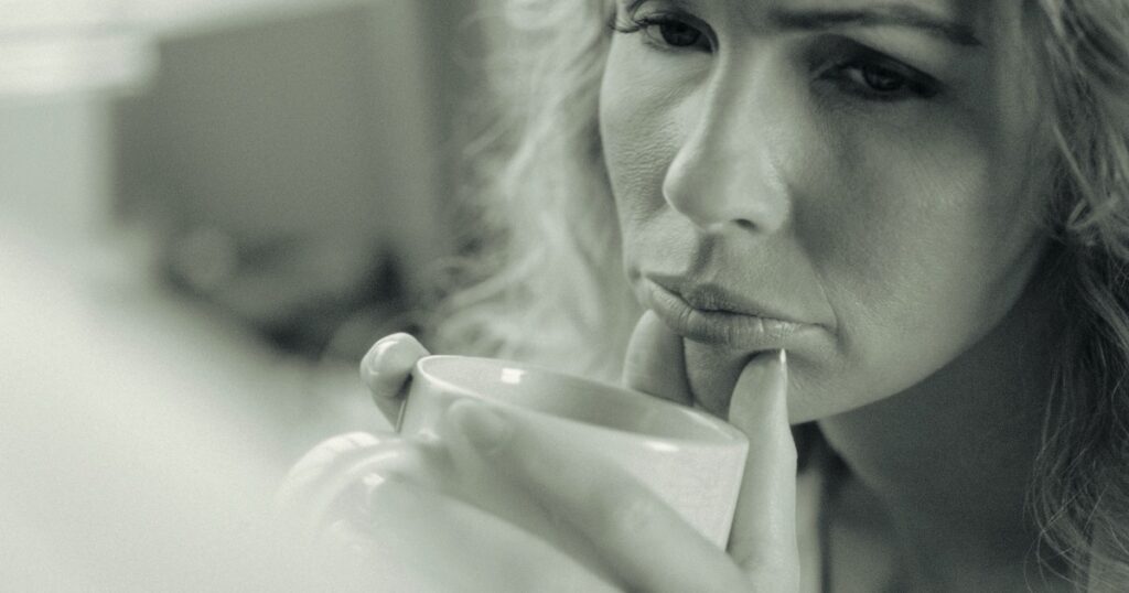 Woman quietly reflecting one year after infidelity while healing from betrayal trauma