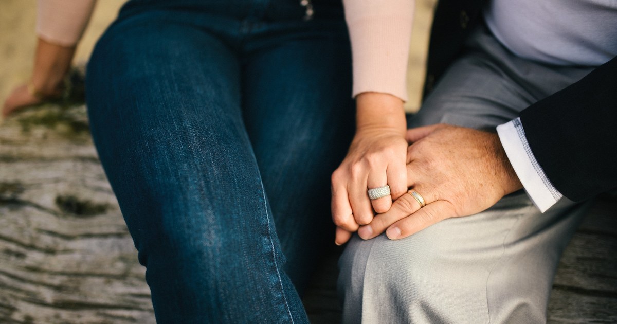 Married couple holding hands while rebuilding trust and emotional connection after infidelity