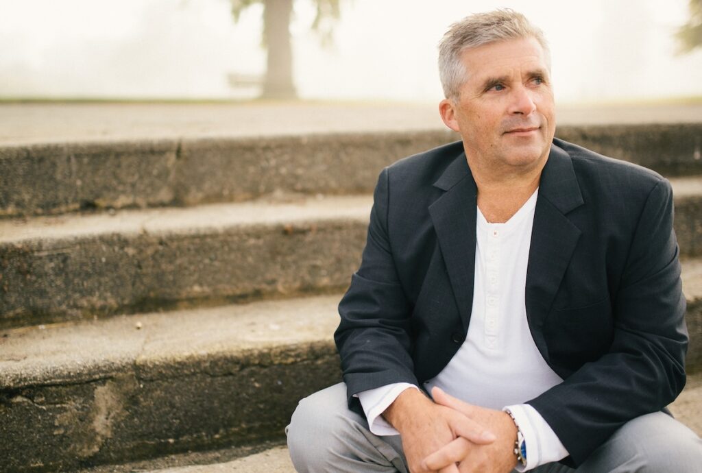 Husband sitting alone in reflection after infidelity, illustrating emotional distance and delayed remorse during affair recovery.